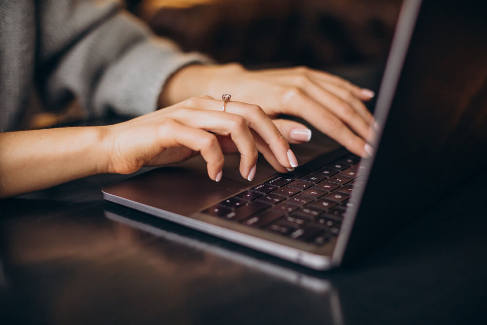 Frau tippt Angaben zur Erwerbsminderungsrente am Laptop ein